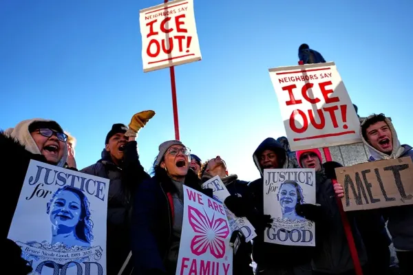 Protesters chanting and holding signs that say, "ICE OUT!" and "Justice for Renee Good"