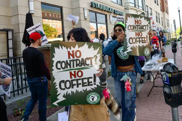 Picketers holding signs and picketing outside Albany, NY Starbucks store.