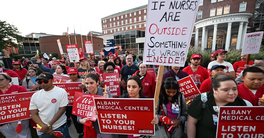 Crowd of nursese holding sign outside Albany Med