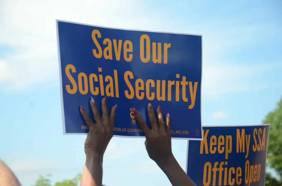 Woman holding a sign that reads "Save Our Social Security"